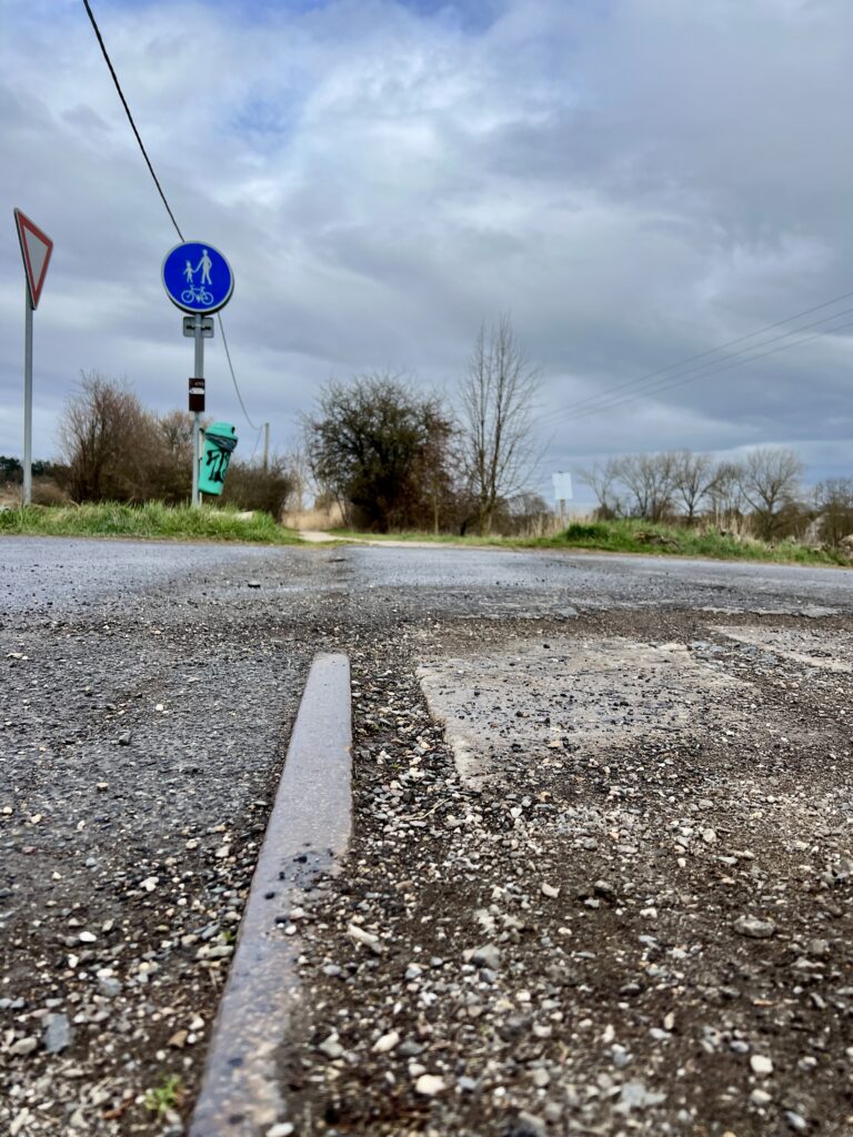 Zbytky kolejí na přejezdu po bý álé železniční trati_cyklostezka